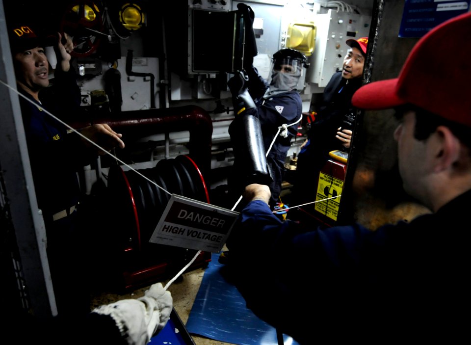 US Navy 100311-N-7280V-204 Chief Electrician's Mate Mateo Canlas and Master Chief Electrician's Mate Ador Barcega direct Hull Maintenance Technician 3rd Class Alex Bonner and Electrician's Mate 3rd Class Gyanand Sookram during