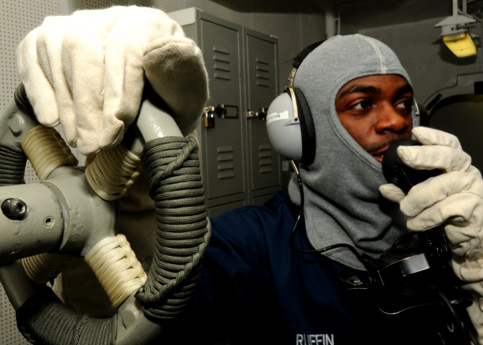 US Navy 100309-N-9793B-079 Boatswain's Mate 1st Class Michael Ruffin communicates with the ship's bridge using a sound-powered telephone during a general quarters drill