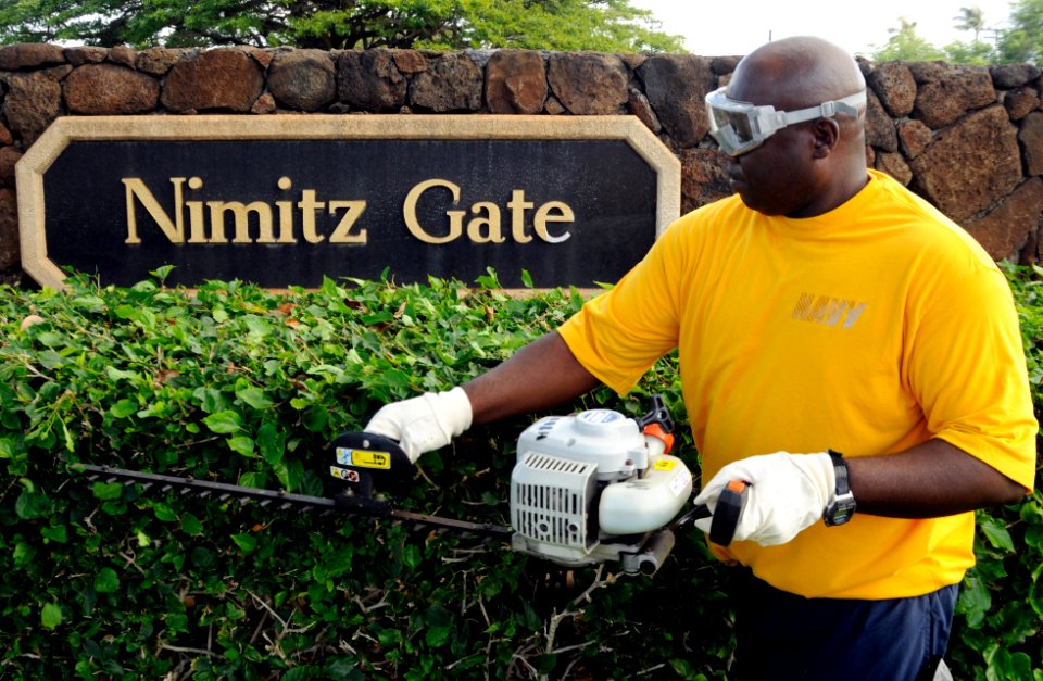 US Navy 100309-N-7498L-003 Chief Boatswain's Mate James Hypolite, assigned to the 1st Lt. Division at Joint Base Pearl Harbor-Hickam, trims the hedges at the Nimitz Gate during the installation-wide base cleanup