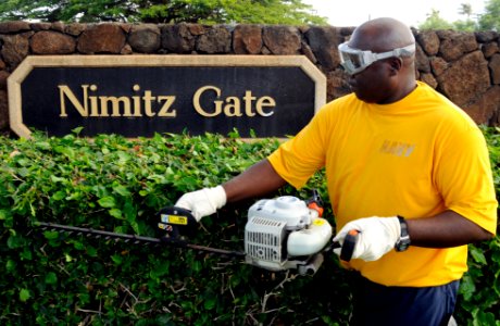 US Navy 100309-N-7498L-003 Chief Boatswain's Mate James Hypolite, assigned to the 1st Lt. Division at Joint Base Pearl Harbor-Hickam, trims the hedges at the Nimitz Gate during the installation-wide base cleanup