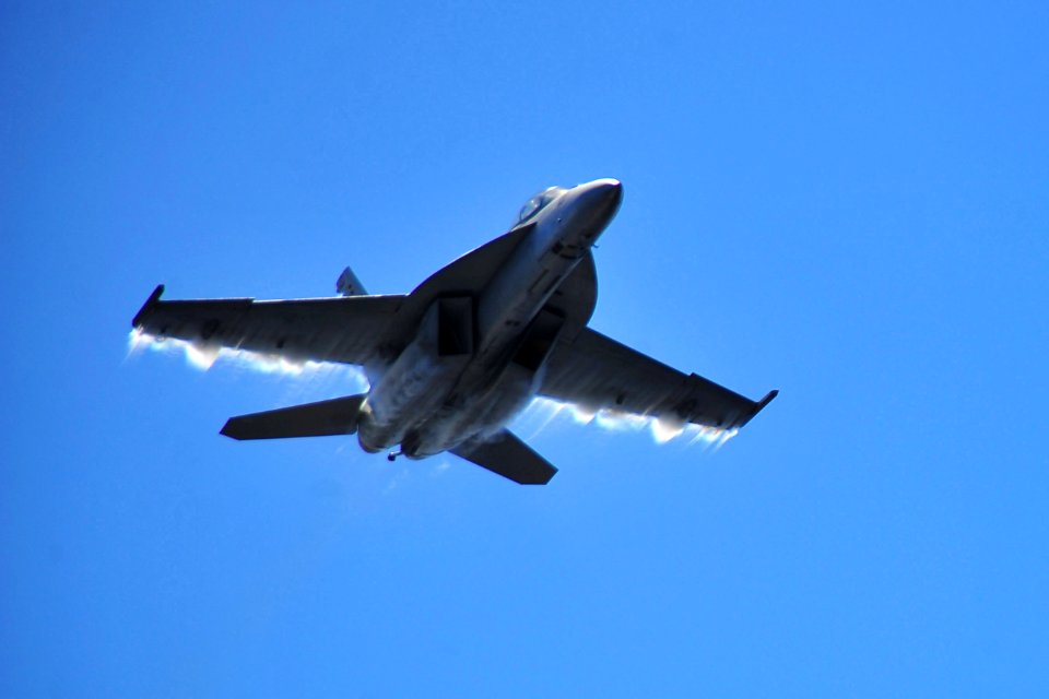 US Navy 100310-N-2953W-274 An F-A-18 Super Hornet performs high-speed maneuvers over the aircraft carrier USS Carl Vinson (CVN 70) during a flight demonstration
