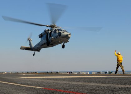 US Navy 100309-N-9950J-397 Aviation Boatswain's Mate (Handling) Patrick Neimeyer directs the lift off of an MH-60S Sea Hawk helicopter assigned to Helicopter Sea Combat Squadron (HSC) 25