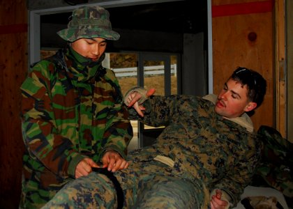 US Navy 100312-N-9573A-004 A Marine assigned to the 3rd Reconnaissance Battalion helps a Republic of Korea marine attach a tourniquet during medical training. The 3rd Reconnaissance Battalion, based in Okinawa, Japan, is in Kor