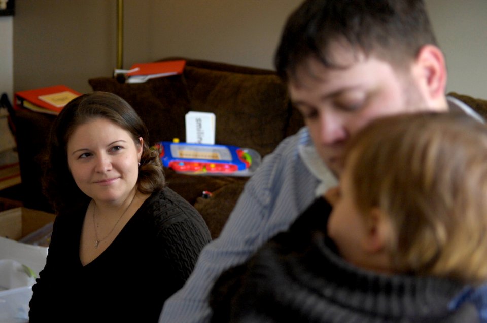 US Navy 100310-N-4178C-002 Master-at-Arms 2nd Class Emily Buster looks on while her husband, Christopher Adams holds their three-year-old son Joey
