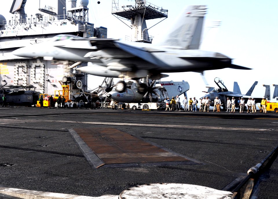 US Navy 100309-N-4236E-337 Distinguished visitors with the Legends of Aerospace Tour watch an F-A-18E Super Hornet prepare to catch an arresting wire