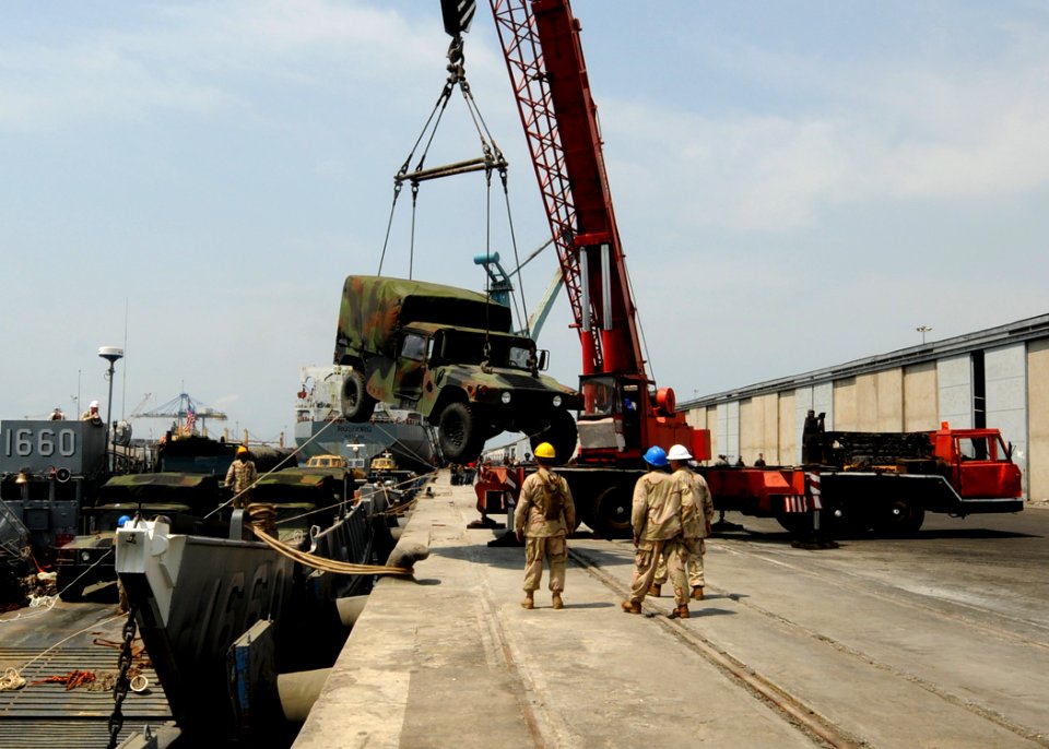 US Navy 100309-N-6676S-109 Sailors assigned to Landing Craft Unit (LCU) 1660 watch as a truck is craned onto the pier in Tema, Ghana