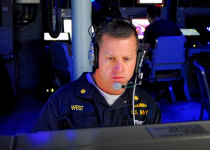 US Navy 100310-N-7058E-054 Lt. Cmdr. Mark West stands the tactical action officer watch in the mission control center aboard the littoral combat ship USS Freedom (LCS 1) photo