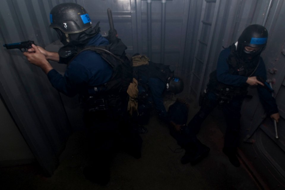 US Navy 100309-N-7498L-013 Sailors secure a smoke-filled space as a team member apprehends a target during the advanced Security Reaction Force course scenarios at the Center for Security Forces Pearl Harbor learning site