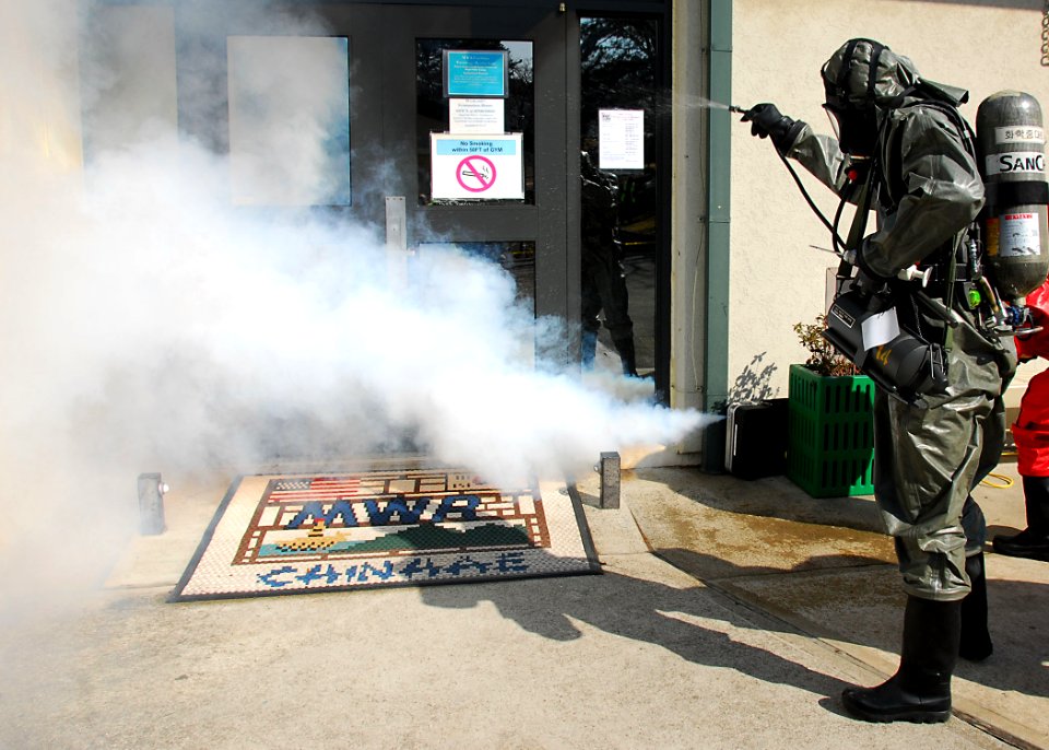 US Navy 100311-N-9573A-009 A Republic of Korea chemical company employee washes down a simulated contaminated area outside the base gym