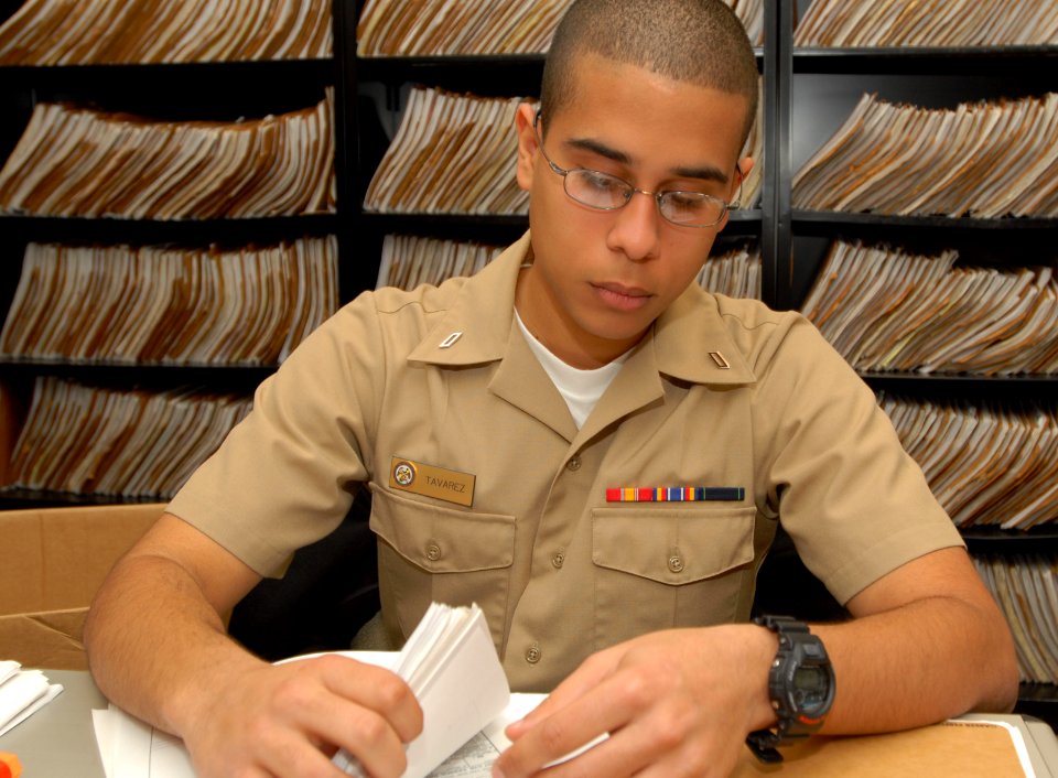 US Navy 100312-N-0486G-002 Personnel Specialist Seaman Apprentice Bernardo Tavarez sorts through a field service record at Personnel Support Detachment Mayport