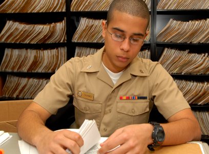 US Navy 100312-N-0486G-002 Personnel Specialist Seaman Apprentice Bernardo Tavarez sorts through a field service record at Personnel Support Detachment Mayport
