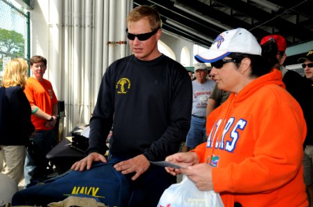 US Navy 100315-N-5366K-068 Aircrew Survival Equipmentman 1st Class Thomas Kinn shows a spectator his parachute after the team performed during the opening ceremony of a Pittsburgh Pirates baseball game at McKechnie Field