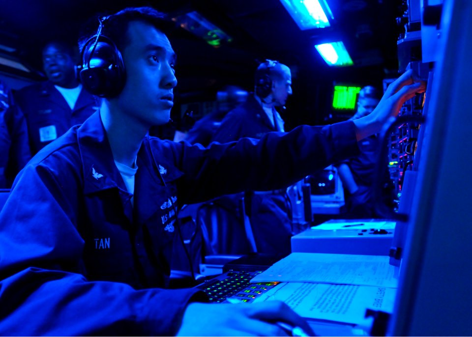 US Navy 100312-N-9950J-052 Operations Specialist 3rd Class Eric Tan stands watch in the combat information center aboard the forward-deployed amphibious assault ship USS Essex (LHD 2)