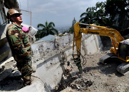 US Navy 100313-N-5961C-007 Gunner's Mate 2nd Class Timothy Gandini serves as a spotter for heavy machinery operators during recovery operations at the Hotel Montana