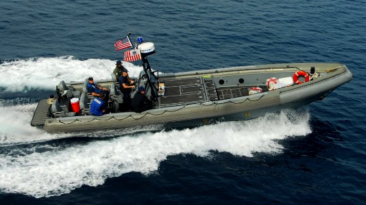 US Navy 100312-N-7058E-123 Sailors and Coast Guardsmen from the littoral combat ship USS Freedom (LCS 1) use a rigid-hull inflatable boat to retrieve bales of cocaine dumped overboard by a small boat