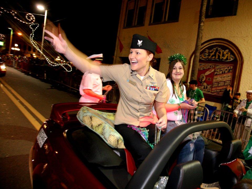 US Navy 100313-N-3271W-318 Mass Communication Specialist 1st Class Monica Nelson throws beads along the parade route at a St. Patrick's Day Parade in Tampa. Fla