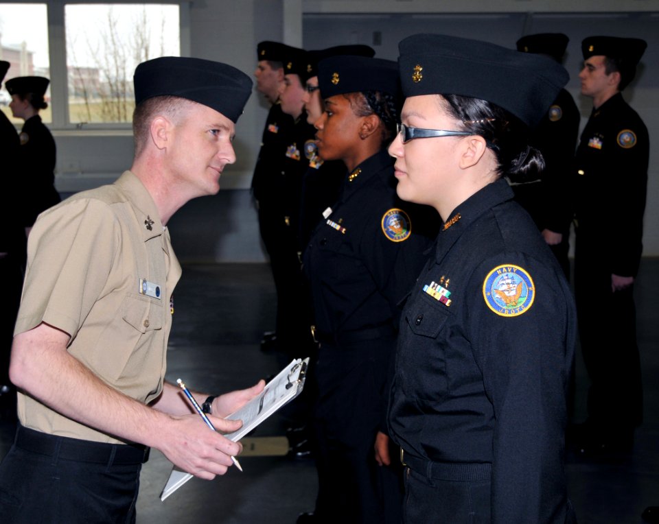US Navy 100313-N-8848T-331 Aviation Structural Mechanic 1st Class Ken Snider, left, a recruit division commander at Recruit Training Command, inspects cadets from Taft High School in Chicago