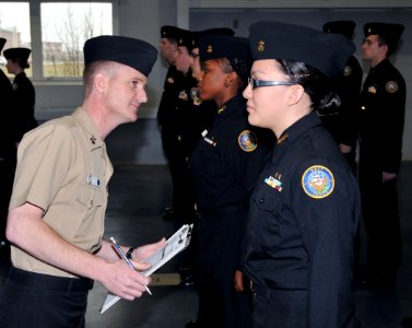 US Navy 100313-N-8848T-331 Aviation Structural Mechanic 1st Class Ken Snider, left, a recruit division commander at Recruit Training Command, inspects cadets from Taft High School in Chicago photo