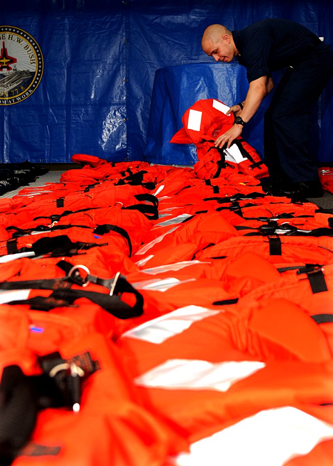US Navy 100313-N-7908T-071 Seaman Bryam Gil prepares life jackets for inspection