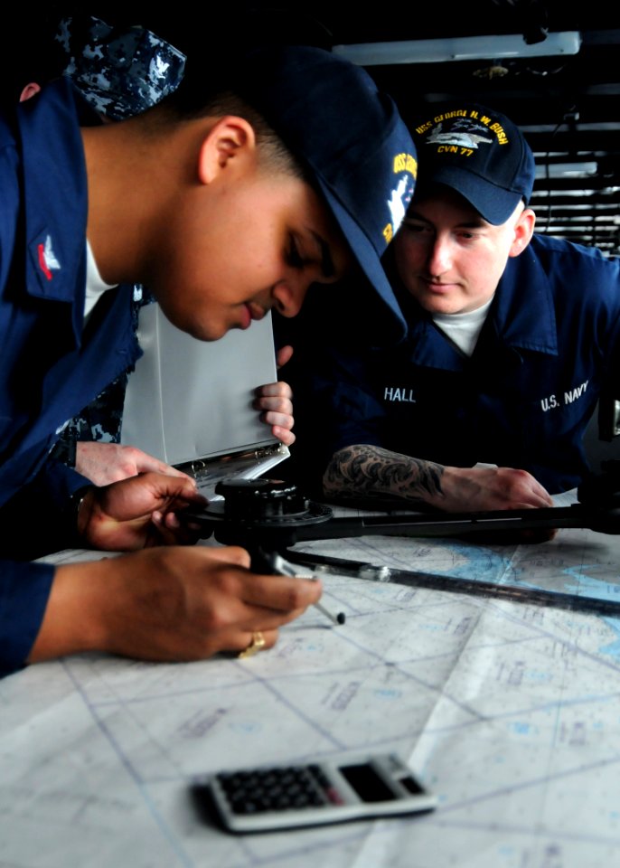 US Navy 100316-N-9793B-022 Quartermaster Seaman Ryan P. Hall, right, watches Quartermaster 2nd Class Paulino Martinez chart a course aboard the aircraft carrier USS George H.W. Bush (CVN 77)