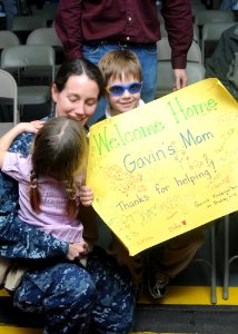 US Navy 100313-N-6764G-039 Lt. Cmdr. Robin Lindsay embraces her family after returning to Naval Station Norfolk aboard the Military Sealift Command hospital ship USNS Comfort (T-AH 20)