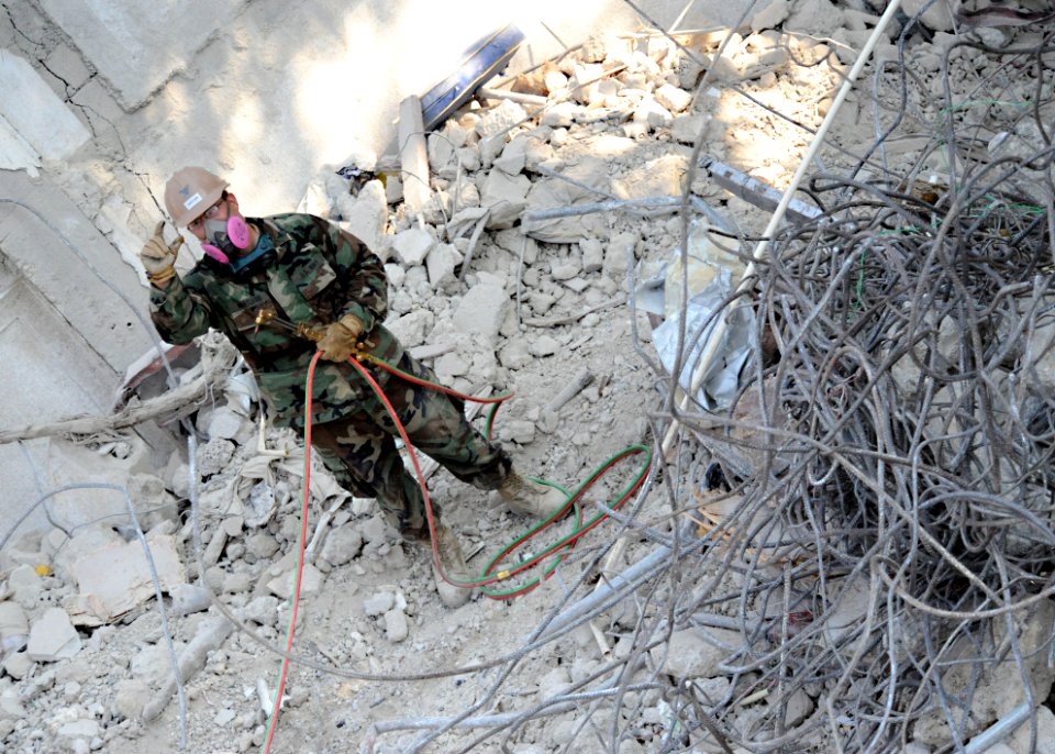 US Navy 100312-N-5961C-007 Construction Electrician 3rd Class Danny Hartless, from Clarksville, Tenn., assigned to Navy Mobile Construction Battalion (NMCB) 7, clears rubble and rebar from the demolished Hotel Montana