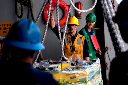 US Navy 100313-N-5712P-122 Boatswain's Mate 2nd Class Chris Briggs signals to Sailors aboard USS Nassau (LHA 4)