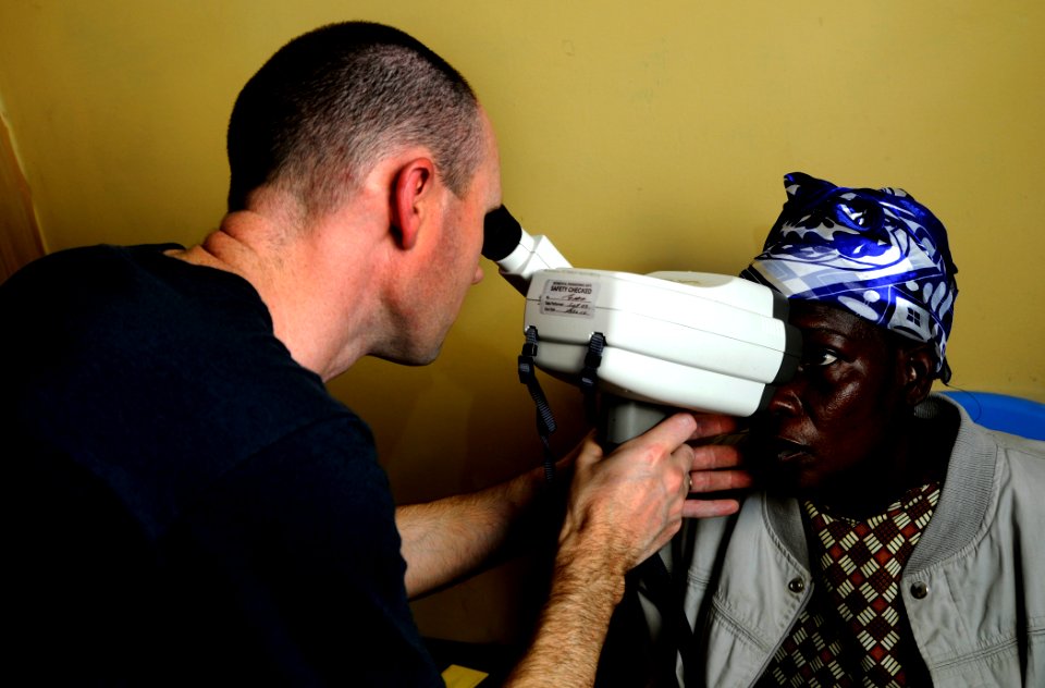US Navy 100317-N-7948C-109 Lt. Cmdr. Mike Sunman conducts an eye examination on a Ghanaian woman during a medical outreach program at Manhean Health Center