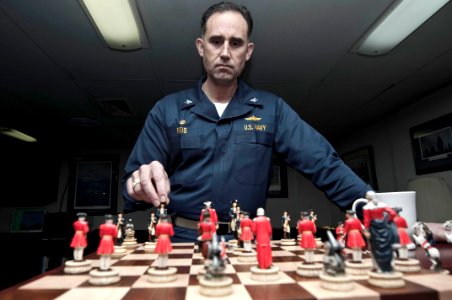 US Navy 100314-N-5712P-006 Capt. Ronald Reis, commanding officer of the amphibious assault ship USS Nassau (LHA 4), contemplates a move on the Revolutionary War chess set in his stateroom