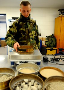 US Navy 100315-N-1120L-012 Engineering Aide Constructionman Christopher Kumpf, a Seabee assigned to Naval Mobile Construction Battalion (NMCB) 7., weighs soil samples photo