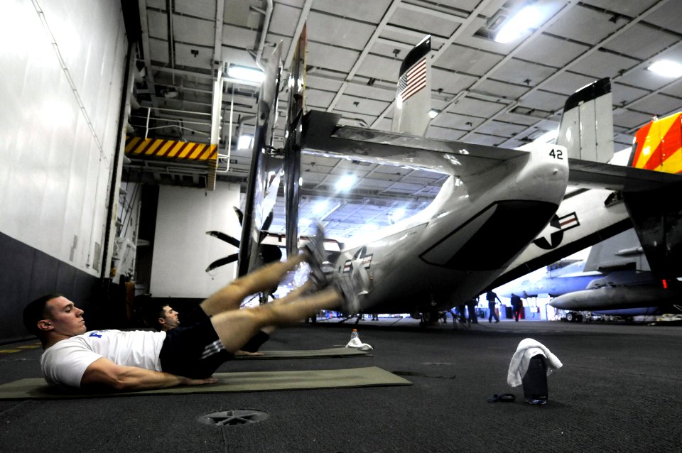 US Navy 100316-N-4275C-026 Naval Air Crewmen 3rd Class Richard Coury and Kristopher Strand perform abdominal exercises aboard USS Carl Vinson (CVN 70)