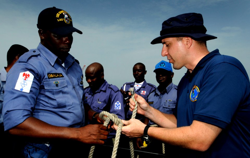 US Navy 100315-N-7948C-116 Coast Guard Chief Warrant Officer 3 Earl Schlemmer shows Nigerian navy Petty Officer Ademola Obalaja proper knot-tying techniques during a basic small boat operation workshop