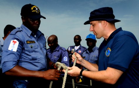 US Navy 100315-N-7948C-116 Coast Guard Chief Warrant Officer 3 Earl Schlemmer shows Nigerian navy Petty Officer Ademola Obalaja proper knot-tying techniques during a basic small boat operation workshop photo