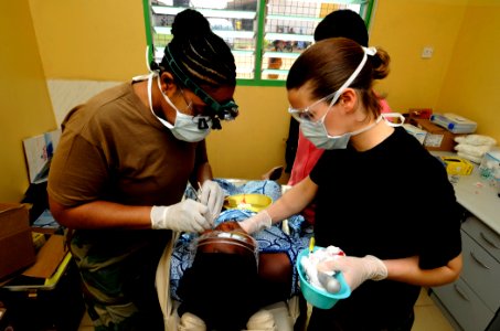 US Navy 100317-N-7948C-039 Air Force Capt. Paulencia Morris and Staff Sgt. Jennifer Hurley examine a Ghanaian woman during a dental outreach program at Manhean Health Center