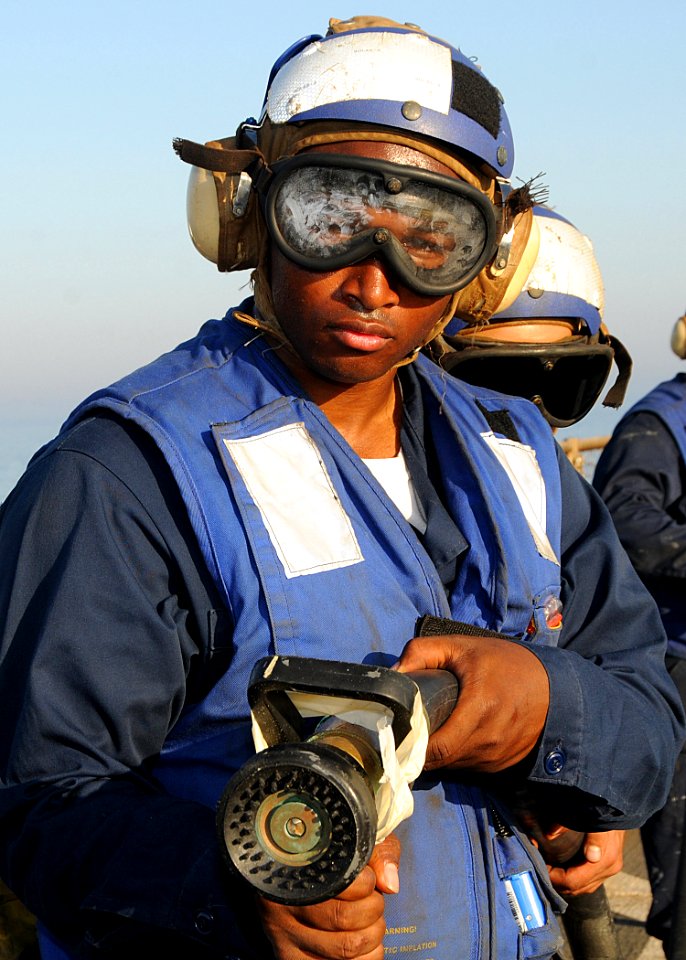 US Navy 100317-N-1082Z-047 Boatswain's Mate 3rd Class Curtis Broidy, from Washington D.C., acts as lead nozzle man during an emergency flight quarters drill aboard the amphibious dock landing ship USS Ashland (LSD 48)