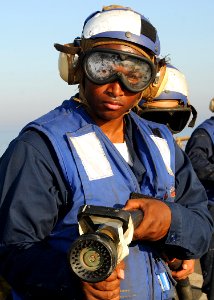US Navy 100317-N-1082Z-047 Boatswain's Mate 3rd Class Curtis Broidy, from Washington D.C., acts as lead nozzle man during an emergency flight quarters drill aboard the amphibious dock landing ship USS Ashland (LSD 48)