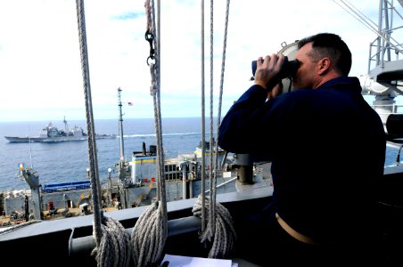 US Navy 100318-N-4275C-485 Senior Chief Quartermaster Johnny Myers observes a replenishment at sea between the aircraft carrier USS Carl Vinson (CVN 70)