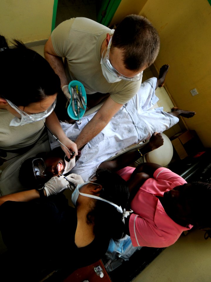 US Navy 100317-N-7948C-082 Air Force Capt. Eirleen Hyun performs a dental examination on a Ghanaian patient as dental assistant Air Force Sgt. Michael Wilde and Air Force Airman 1st Class Sable Price assists her