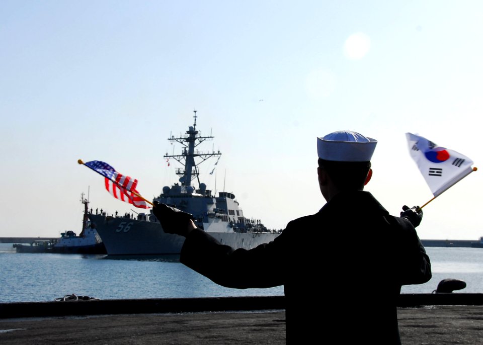 US Navy 100319-N-9573A-005 A Republic of Korea sailor waves the American flag and Republic of Korea flag as the guided-missile destroyer USS John S. McCain (DDG 56) arrives in Donghae