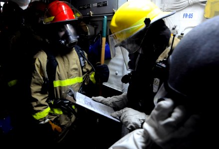 US Navy 100318-N-7280V-321 Damage Controlman 2nd Class William Julian dispatches the assessment team for damage control repair station 5 aboard the U.S. 7th Fleet command ship USS Blue Ridge (LCC 19)