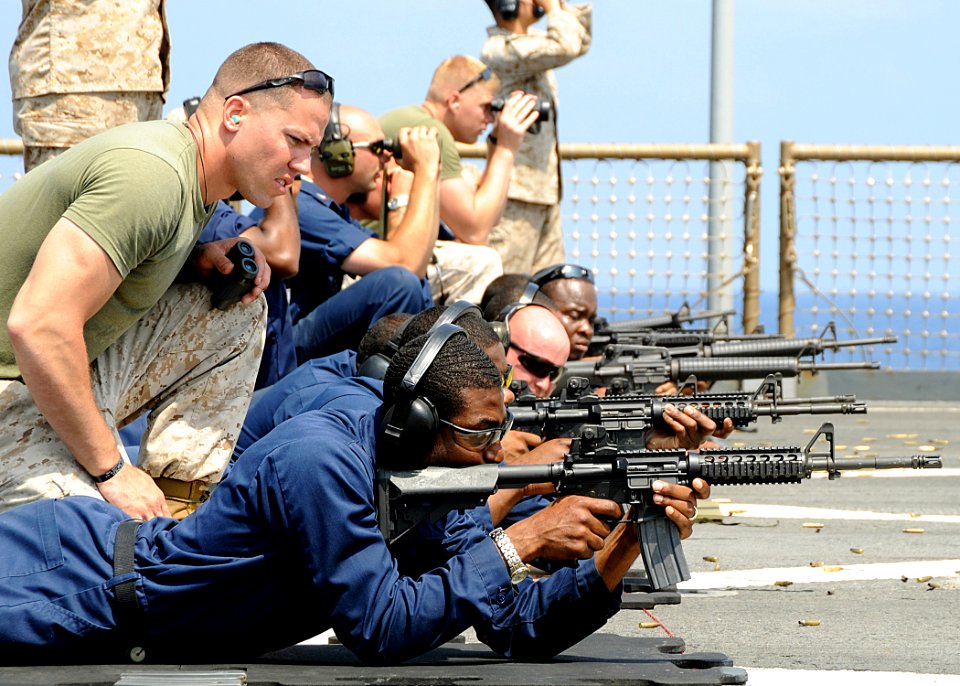 US Navy 100321-N-1082Z-133 Lance Cpl. Benjamin Stroope watches Hospital Corpsman Seaman Richard L. Williams during weapons qualification
