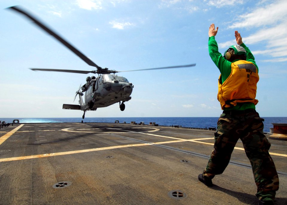 US Navy 100318-N-7058E-161 Aviation Structural Mechanic 3rd Class Nicholas Ellingson from Helicopter Sea Combat Squadron (HSC) 22 signals for an MH-60S Sea Hawk helicopter