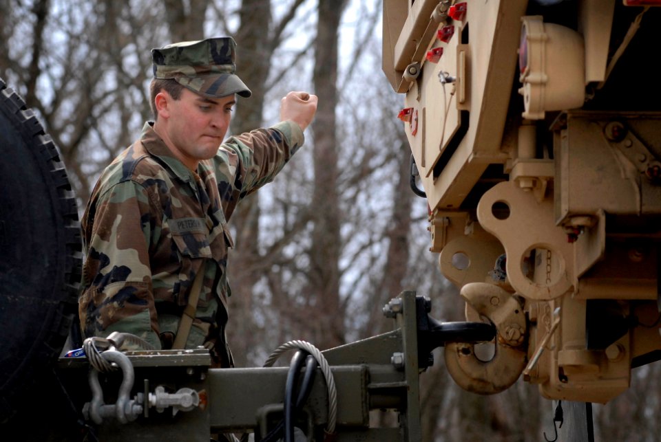 US Navy 100321-N-3136P-071 Construction Mechanic Constructionman Steve Peterson, assigned to Riverine Squadron (RIVRON) 1, signals the driver while connecting the boat trailer onto the truck during a six-day field exercise at F