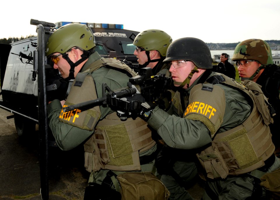 US Navy 100318-N-9860Y-002 Basic Special Weapons and Tactics students move in to scout a building during a barricaded subject entry scenario training evolution