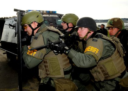 US Navy 100318-N-9860Y-002 Basic Special Weapons and Tactics students move in to scout a building during a barricaded subject entry scenario training evolution