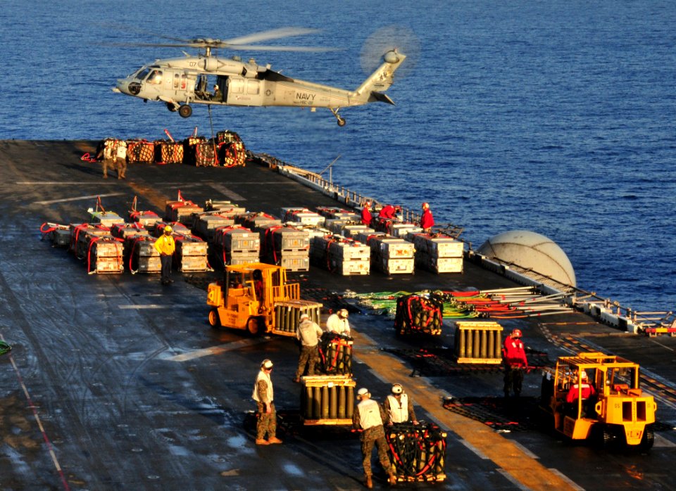 US Navy 100322-N-9740S-013 An MH-60S Sea Hawk helicopter picks up a pallet of ammunition from Bataan
