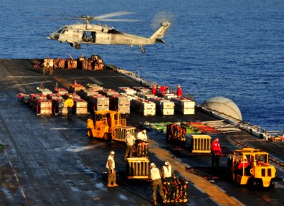 US Navy 100322-N-9740S-013 An MH-60S Sea Hawk helicopter picks up a pallet of ammunition from Bataan photo