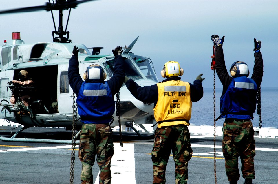 US Navy 100322-N-1226D-279 Aviation Boatswain's Mate (Handling) Airman Donnell Viree counts chock and chains as a UH-1N Huey helicopter prepares to launch aboard USS Peleliu (LHA 5)