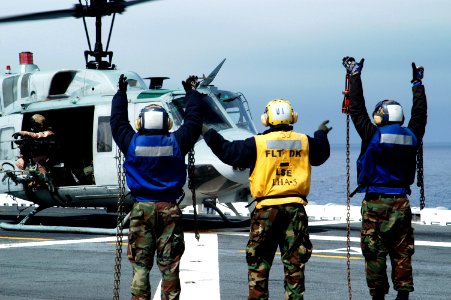 US Navy 100322-N-1226D-279 Aviation Boatswain's Mate (Handling) Airman Donnell Viree counts chock and chains as a UH-1N Huey helicopter prepares to launch aboard USS Peleliu (LHA 5) photo