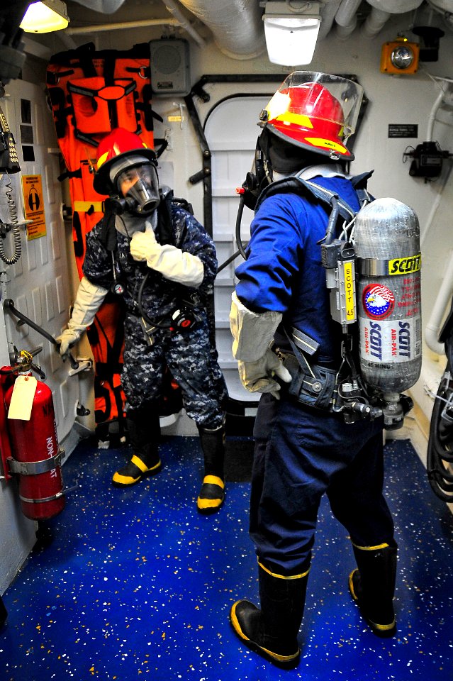 US Navy 100322-N-4774B-581 Logistics Specialist 2nd Class Proceso Mejia and Electrician's Mate Fireman Apprentice Kai Zhong participate in a general quarters drill aboard the guided-missile cruiser USS Bunker Hill (CG 52)